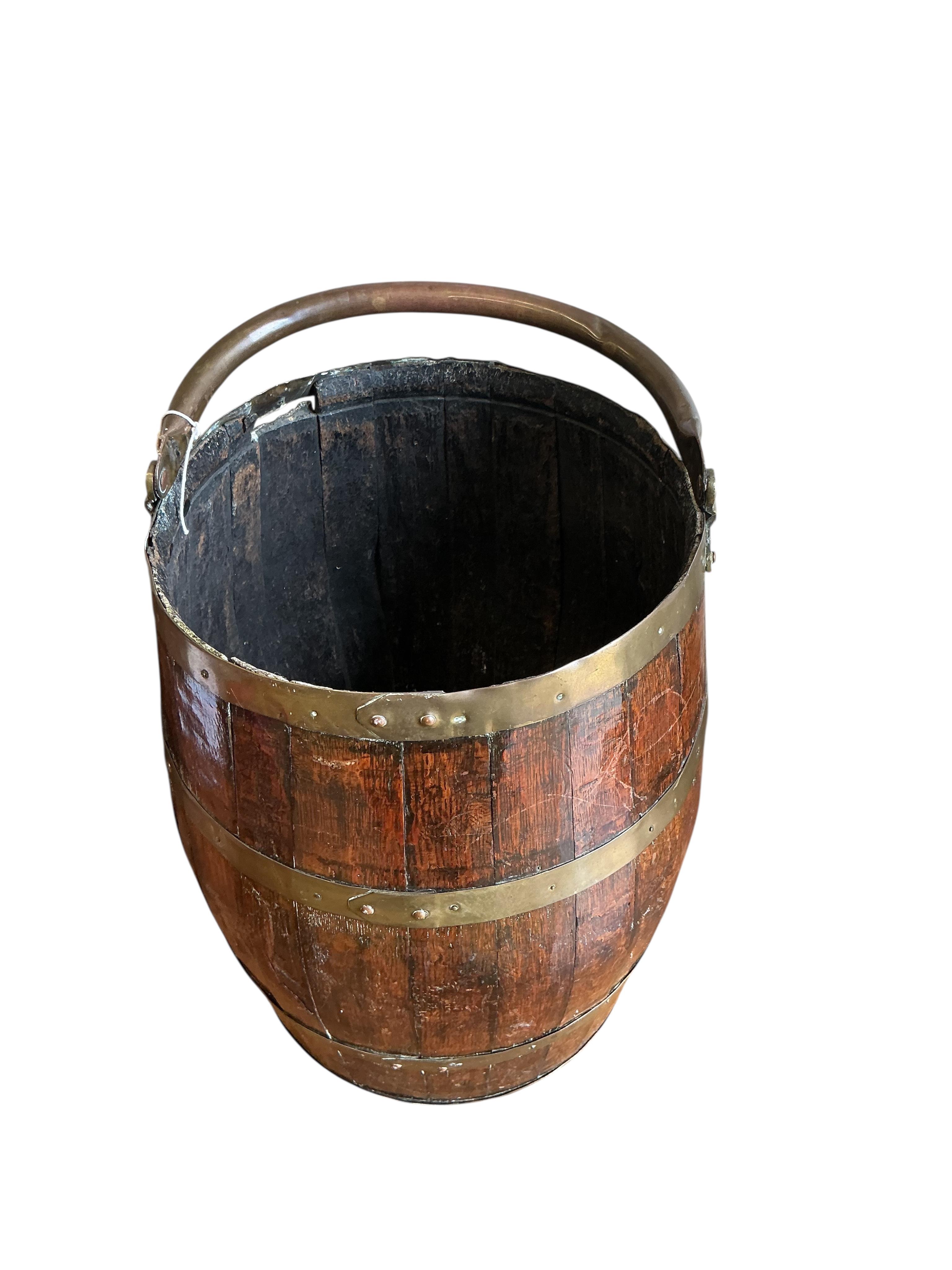 A brass bound coopered oak barrel with swing handle, height 48cm